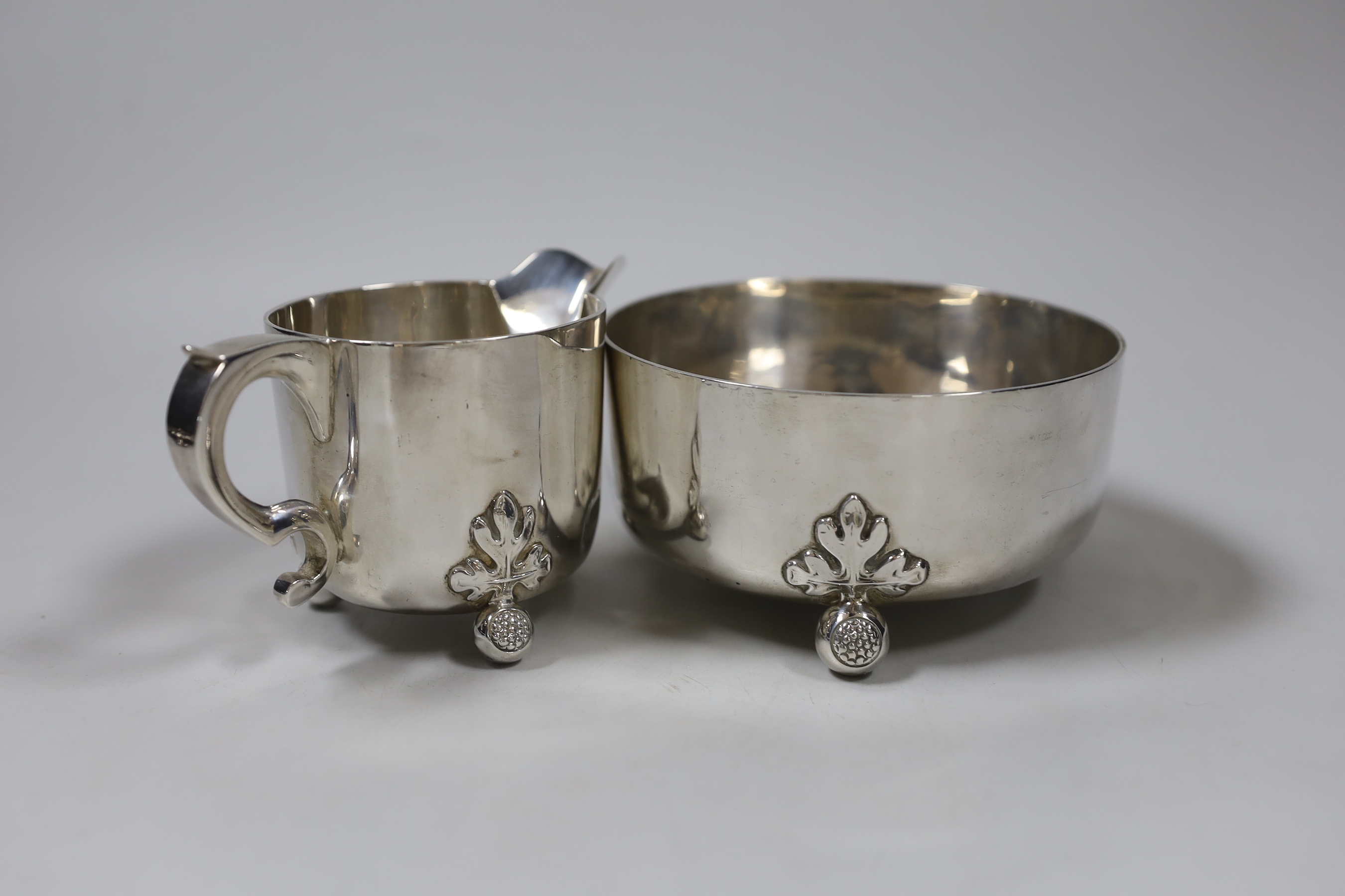 An Edwardian silver cream jug and sugar bowl, on ball feet, by William Comyns, London, 1907, bowl diameter 12,3cm, 12.2oz.